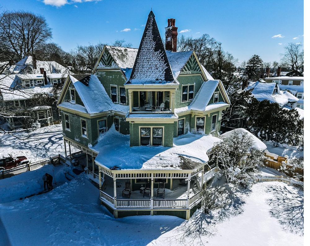 Aerial view of a snow-covered Victorian home