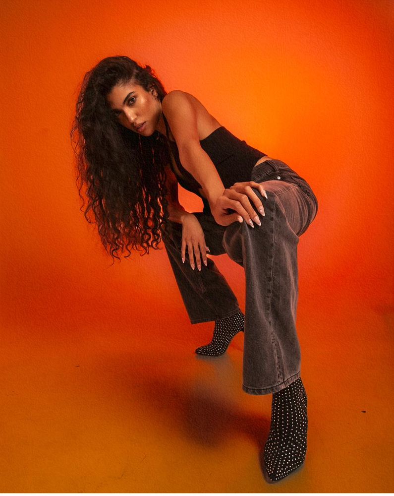 Studio portrait against a bold orange backdrop